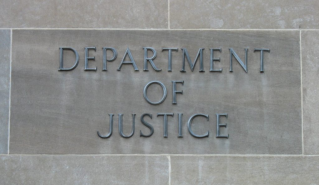 Close up of the Department of Justice lettering on a gray building. Credit to Peter E, Flickr.